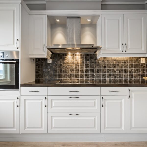 Classic white kitchen cabinets with raised panel doors and black countertops